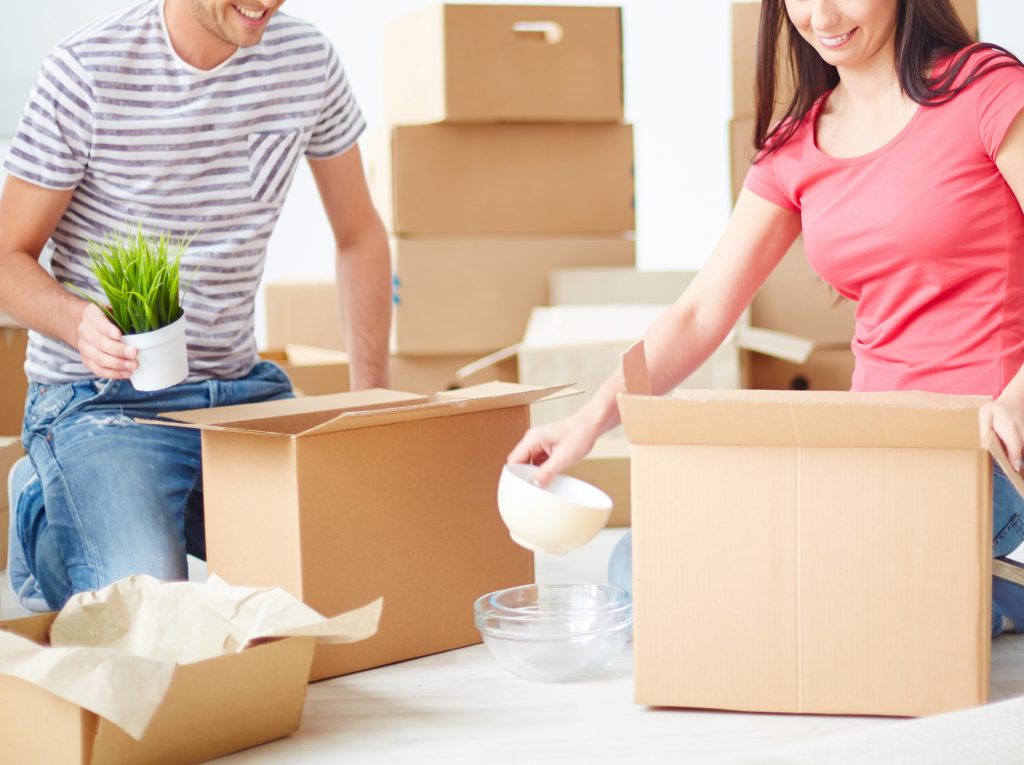 満室運営の実践アイデア掲載! プリマ倶楽部通信2017年2月号 1 Happy young couple sitting on the floor of new flat and unpacking boxes